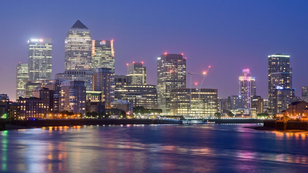 Canary Wharf office towers across the water at dusk.