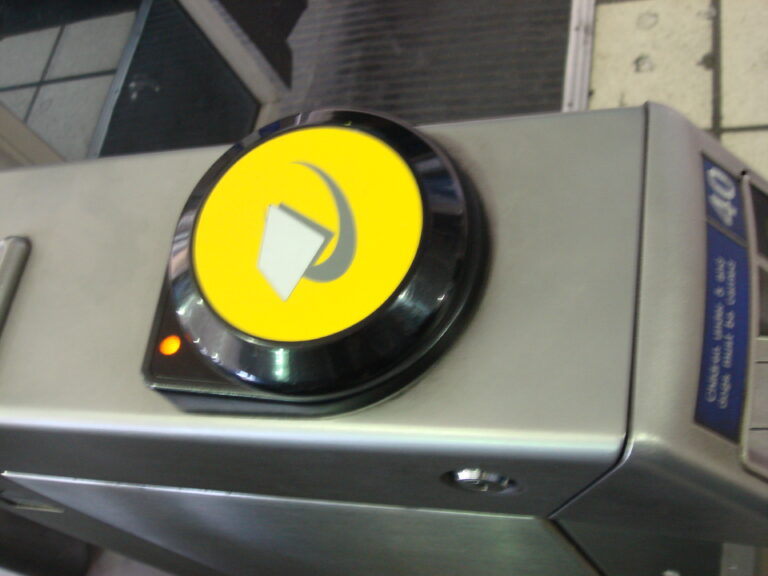 A yellow Oyster card reader on a London Underground ticket barrier.